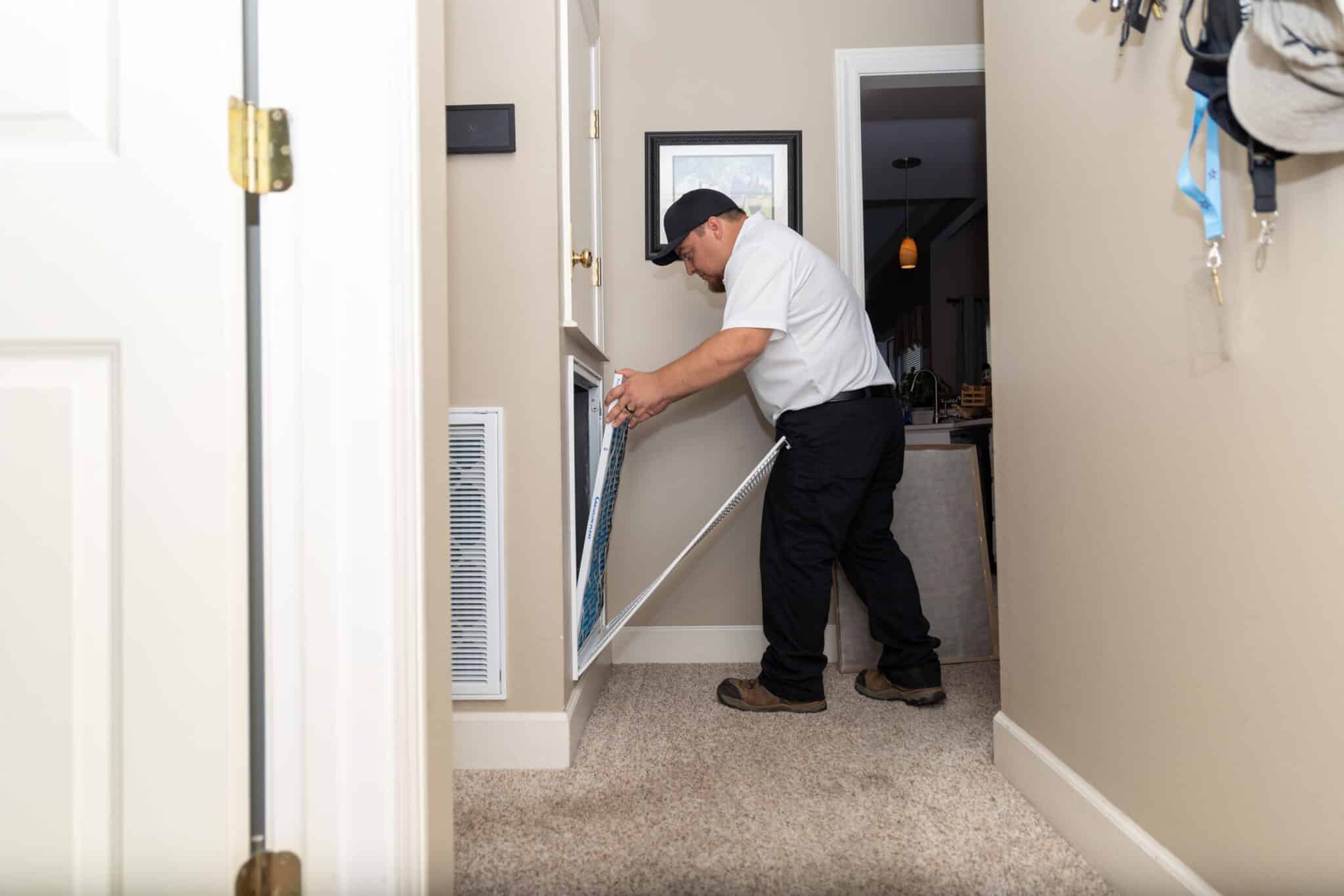 Aire Solutions HVAC technician changing a home air filter for better indoor air quality